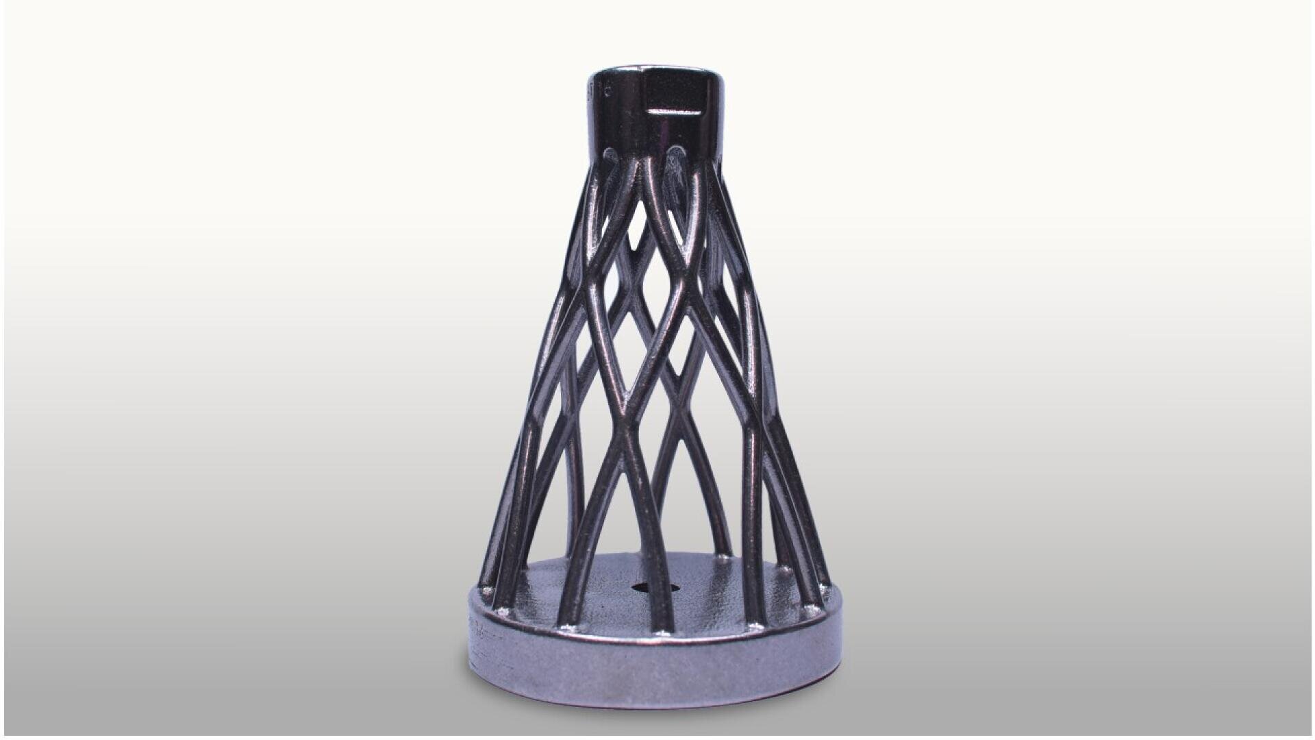 A metallic, cone-shaped object with a lattice structure stands on a solid circular base against a plain, light background.