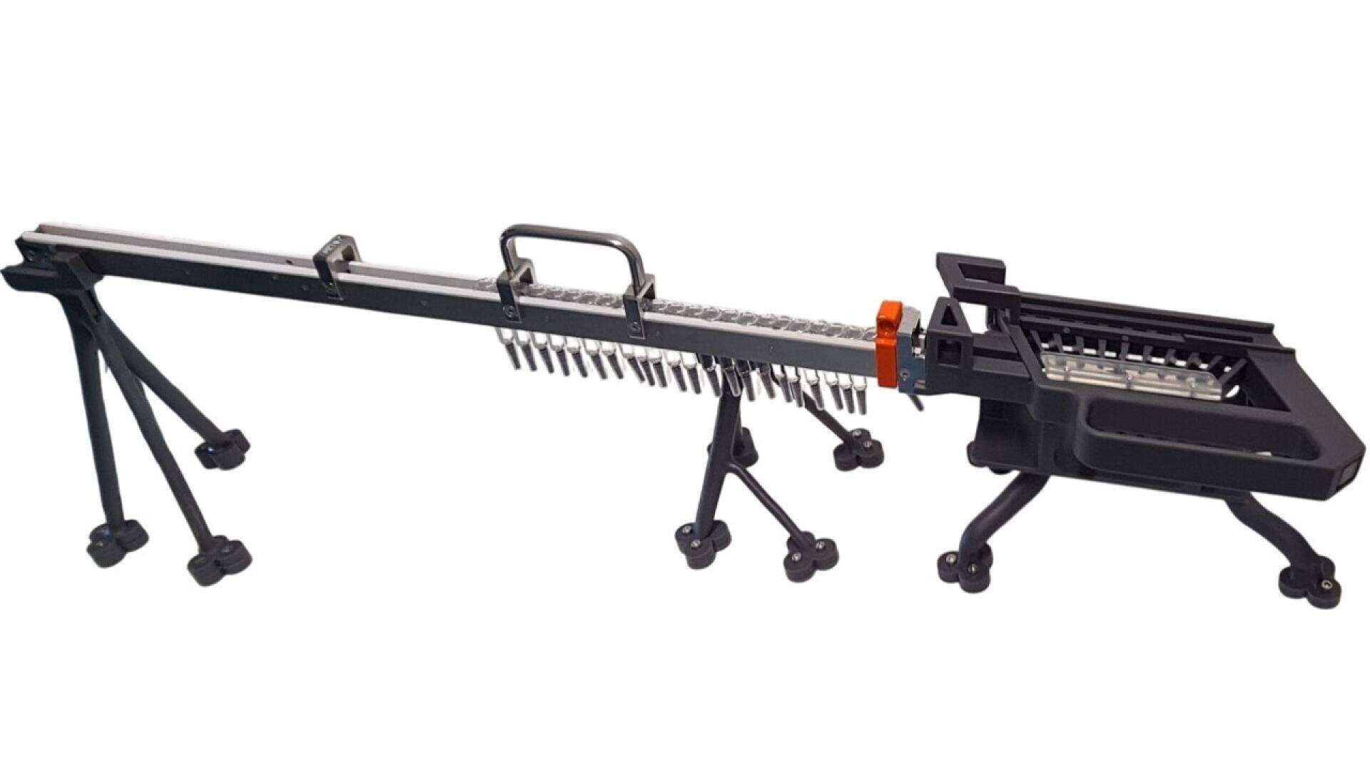 A black and silver metal tool with multiple legs, a handle, and a tray filled with screws, designed for fast and efficient screw installation in construction or assembly work.