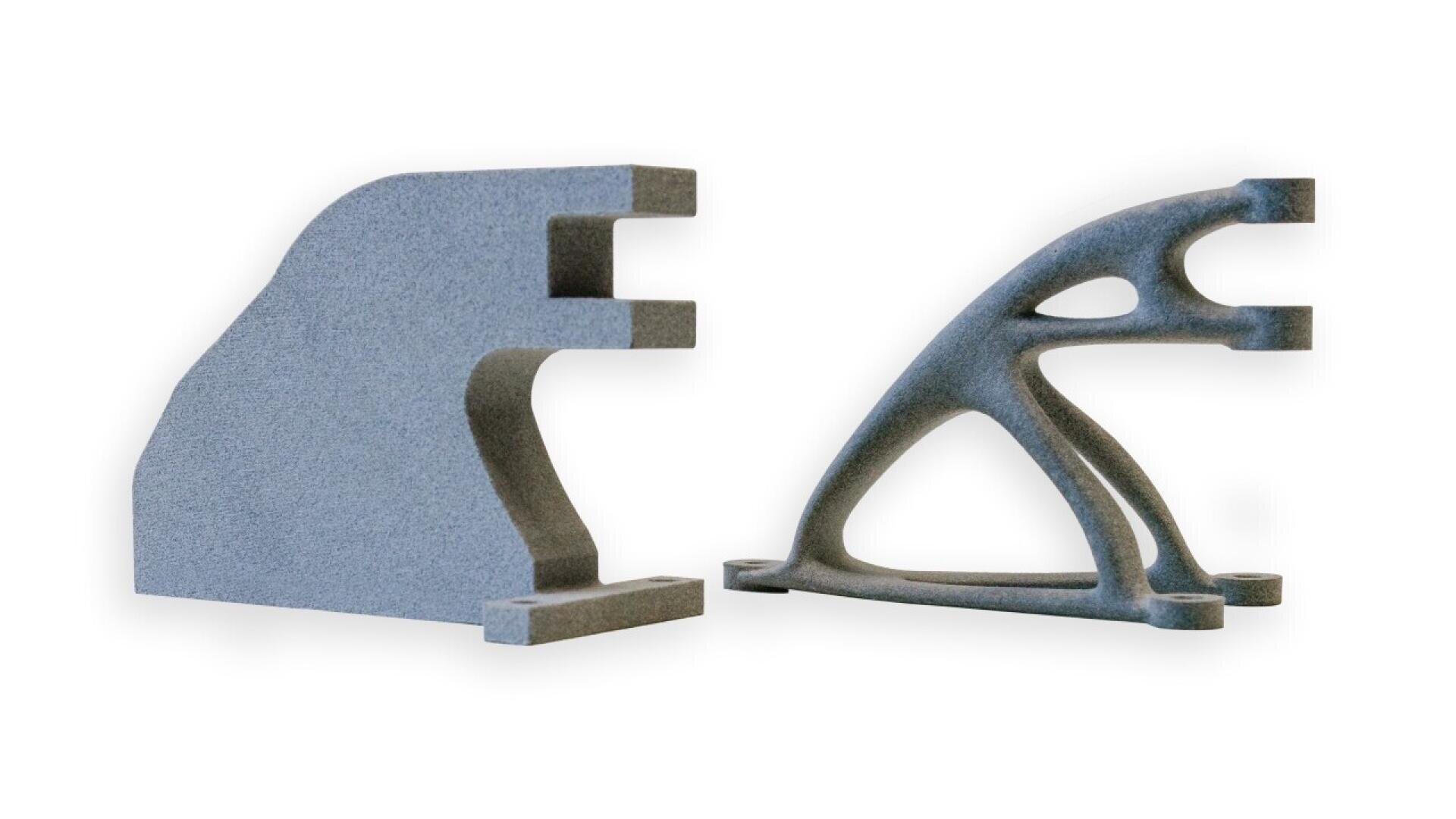 Two gray mechanical parts are shown side by side; the left part has a solid, blocky shape, while the right part has a lightweight, skeletal structure with curved supports.