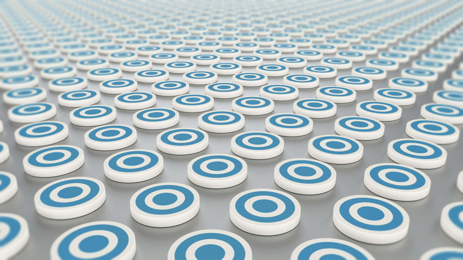 Hundreds of white circular discs with blue bullseye targets are arranged in a grid across a smooth, reflective surface, creating a repetitive and orderly pattern extending into the distance.