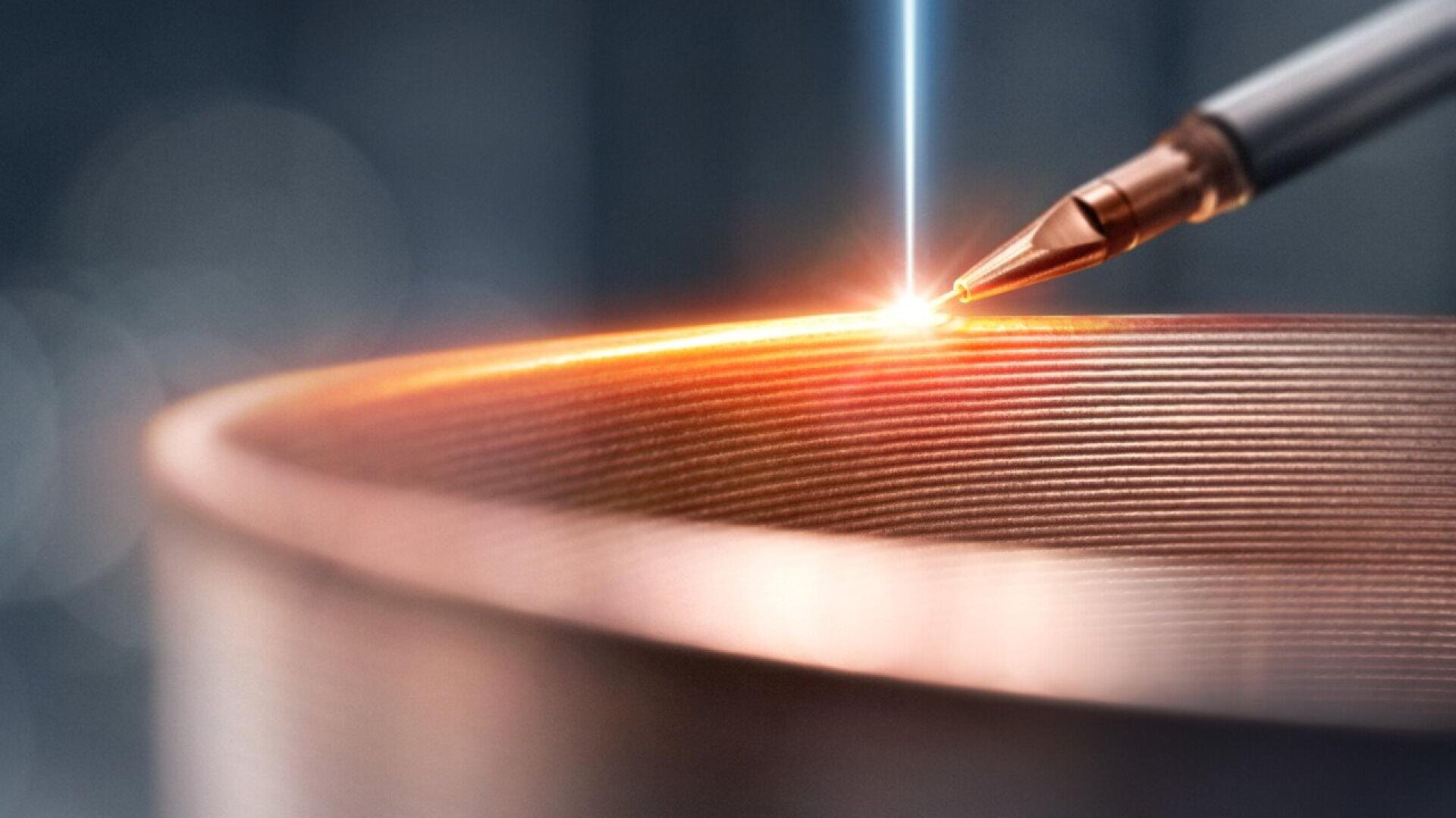 A close-up of a metal 3D printing process, showing a nozzle depositing material layer by layer while a bright laser fuses the metal, forming a precise, textured cylindrical object.