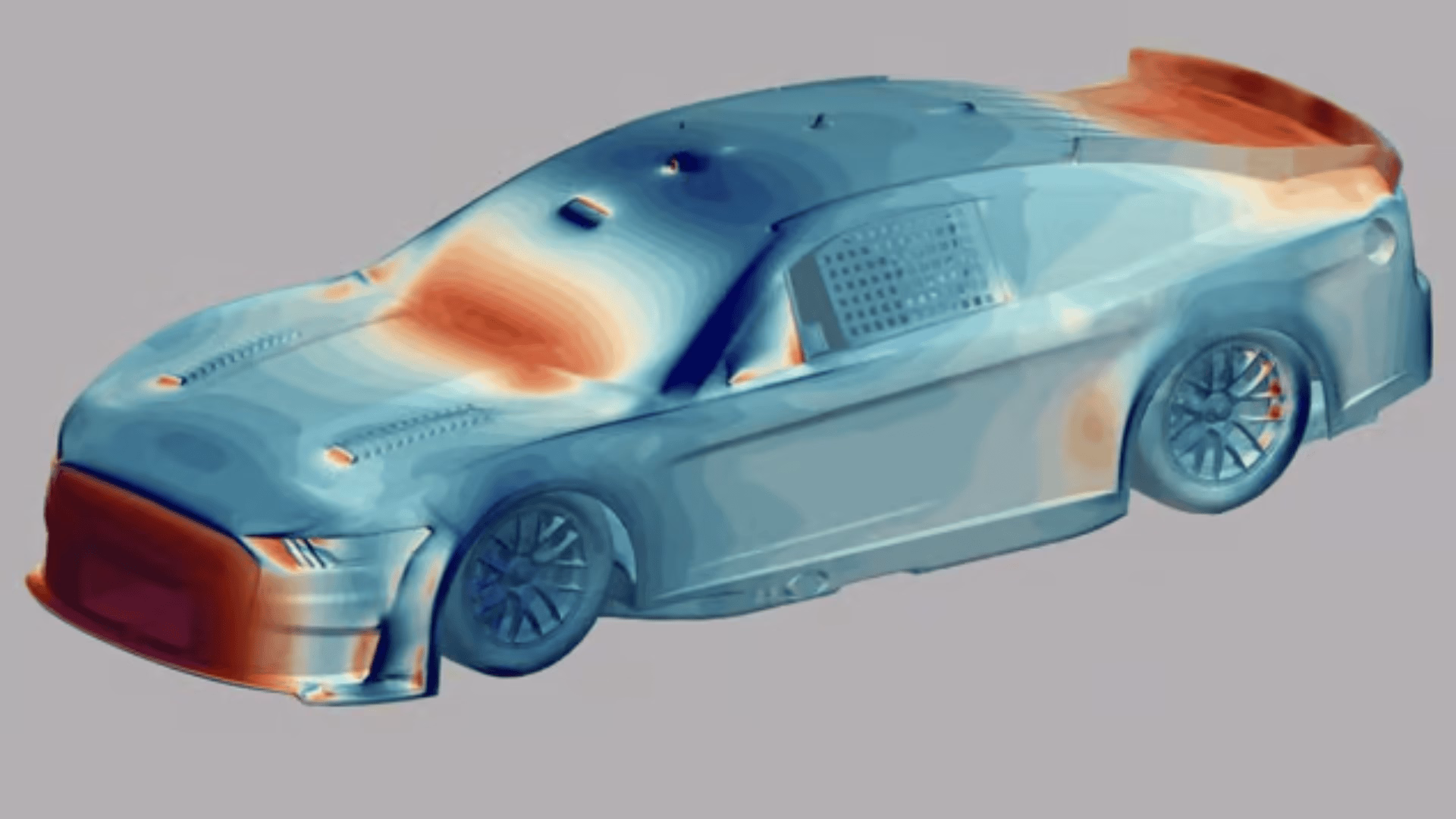 Ein computergeneriertes Bild eines Rennwagens zeigt eine Heatmap-Überlagerung, die Bereiche mit Luftstrom und Druck in den Farben Blau, Rot und Orange auf der Karosserie, der Motorhaube, dem Dach und dem Heckflügel des Wagens hervorhebt.